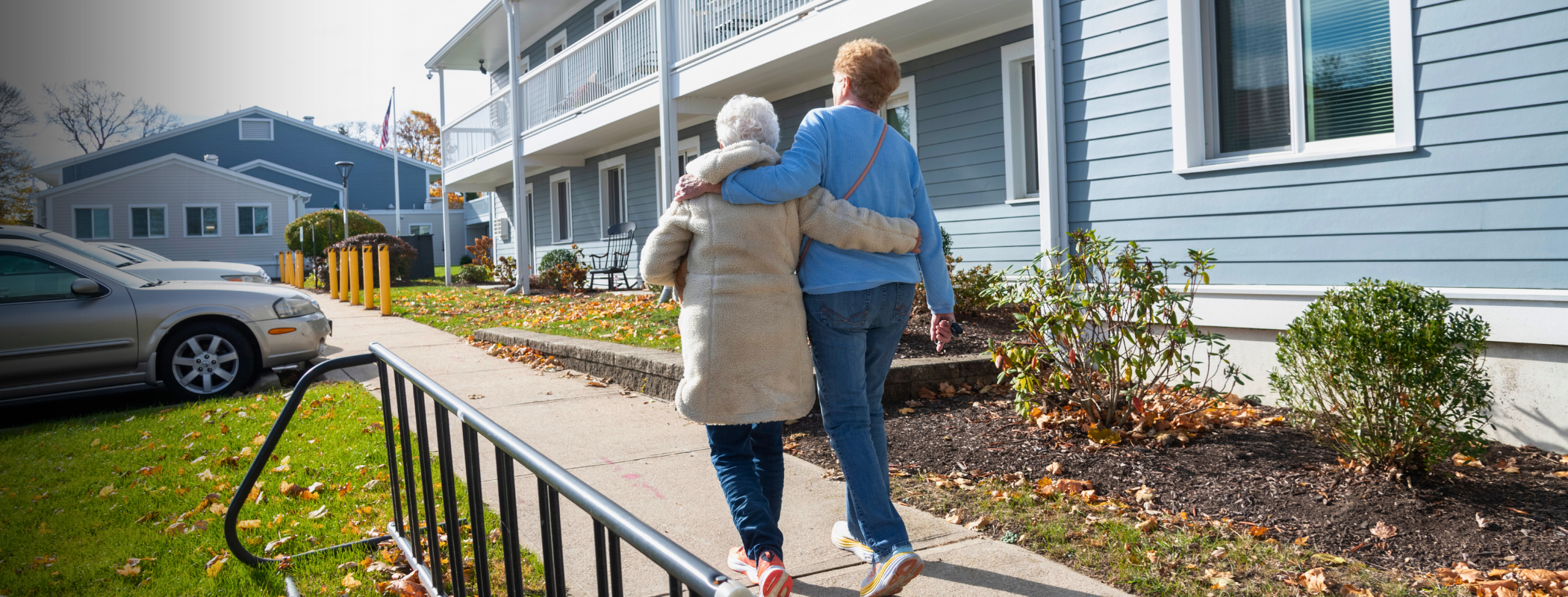 Two residents walking with a hug