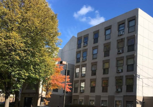 Corcoran Place Apartments brick exterior & trees